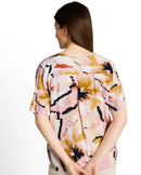 Blusa de mujer de manga corta con cuello pico, cierre frontal de media botonadura y estampado abstracto