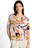 Blusa de mujer de manga corta con cuello pico, cierre frontal de media botonadura y estampado abstracto