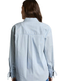 Camisa de manga larga de mujer con cuello clásico, botones y un pequeño bordado en el bolsillo lateral